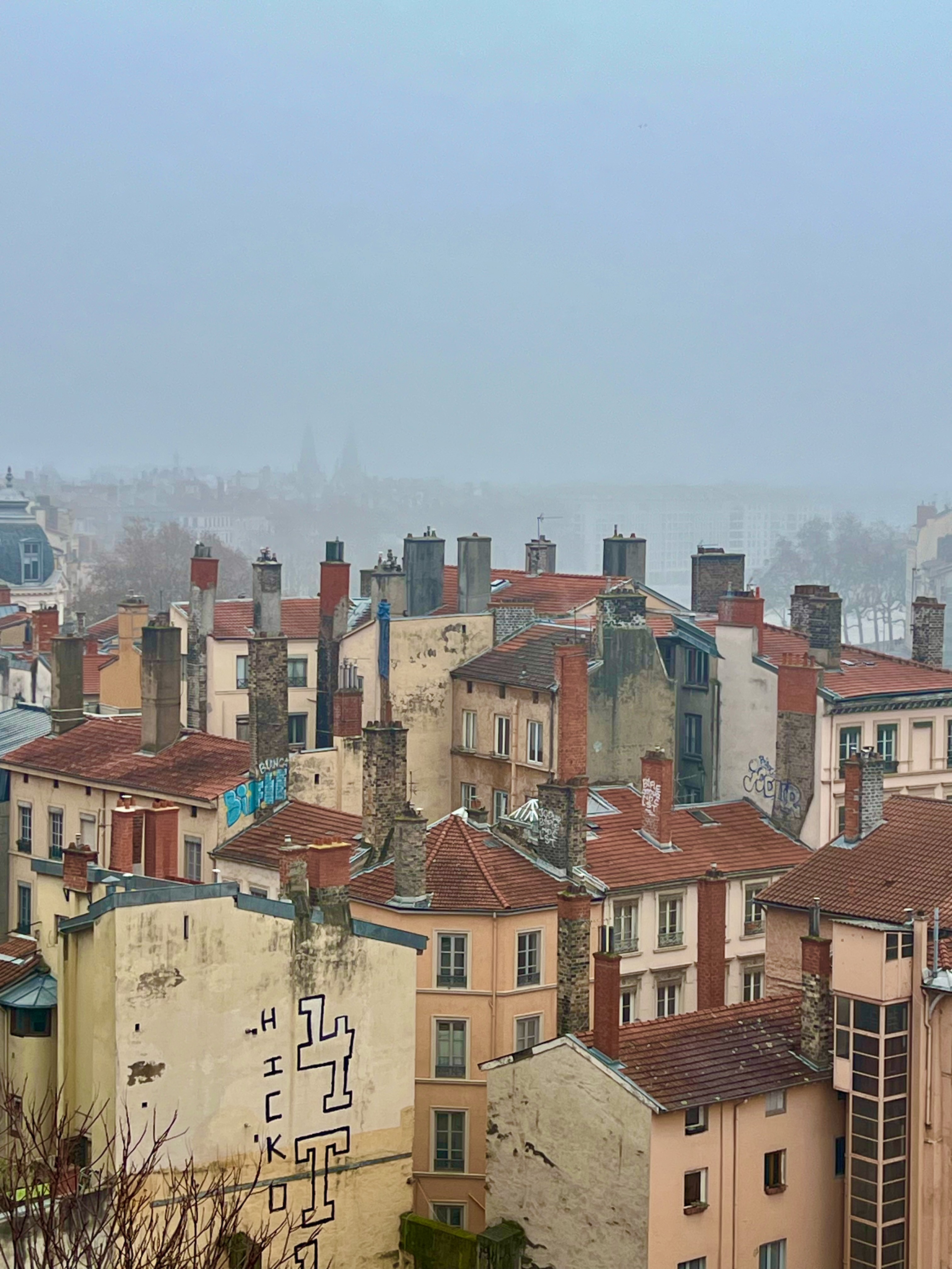 Foggy rooftops and chimneys over the city